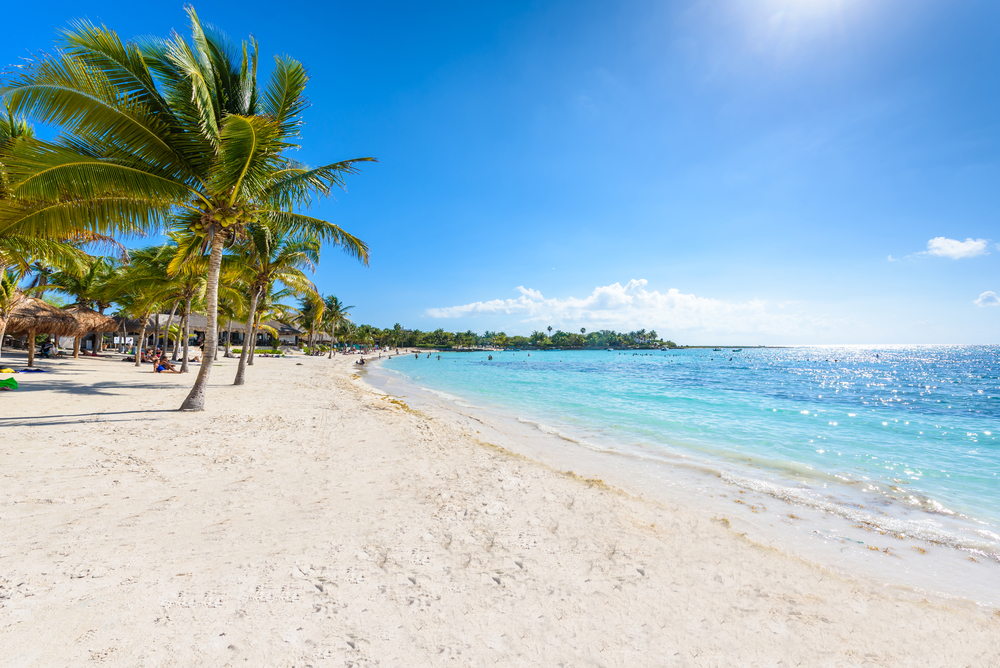 Playa Nizuc en Cancún con aguas tranquilas, rodeada de vegetación y sin multitudes.
